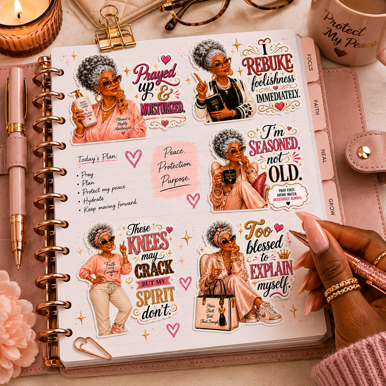 Planner with motivational stickers and a hand holding a pen on a desk.